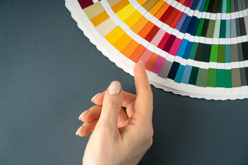 Female finger choosing a color in a catalogue