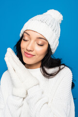 happy woman in knitted hat and gloves isolated on blue