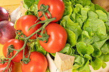 Close up of tomatoes and salad in a small wooden box