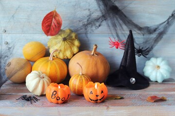 Pumpkins, mystical Halloween decorations, cobwebs, pumpkins, burning candles on a wooden background, autumn, October