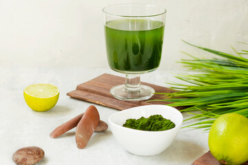 Chlorella detox healthy drink in glass with lime and powder on light background. Superfood, natural antioxidant for a green diet. Anti-aging effect.