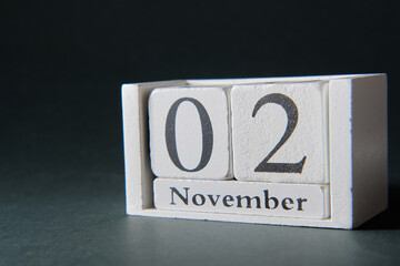 Wooden calendar on dark background, date 2 November