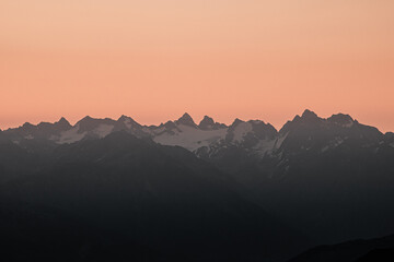 Beautiful Mountain And Sunset at swiss Alps. Dark Silhouette of Mountains on Yellow Sunrise Background