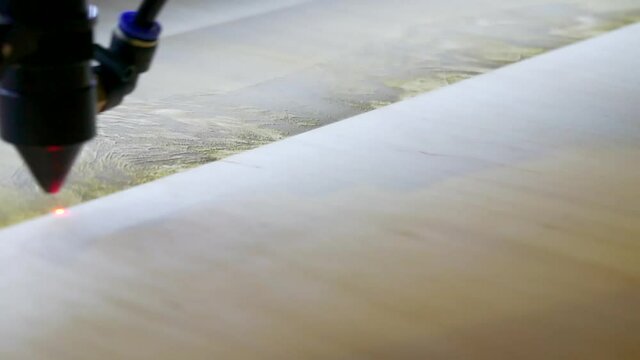 Laser engraving on wood. Laser printer moves on a wooden surface.