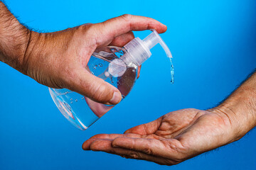 Desinfektionsgel Spender und Hände auf Blau