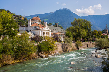 Fototapeta na wymiar The stream Passirio and the Kurhaus building in Merano, south Tyrol, Bolzano province, Italy.