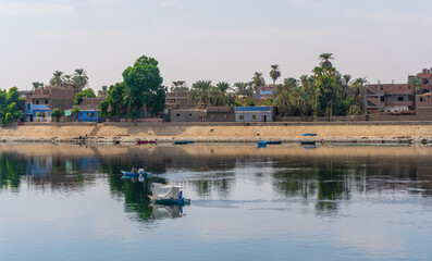 Traditional Egyptian villages on the bank of the river Nile. Views sailing on the cruise on the river Nile from Luxor to Aswer, Egypt