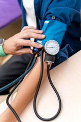 Pediatrician is measuring blood pressure of boy teenager. Selective focus on apparatus. Pediatric concept.