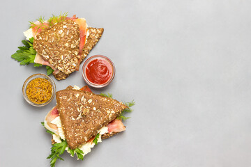 Whole wheat sandwiches with sesame seeds and jamon. Fast food. Bowl of sauce, bowl of mustard