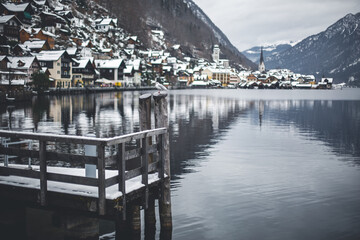 Fototapeta premium Pier witn snow on lake, city view, winter december landscape view. Hallstatt, Austria