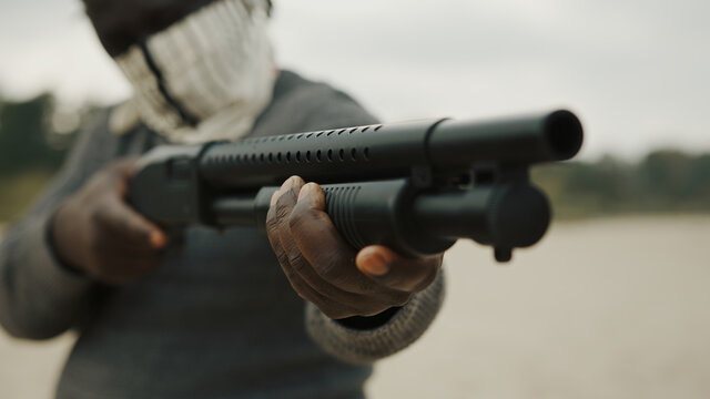 Afro-American man reloads pump action shotgun. Close up. High quality photo