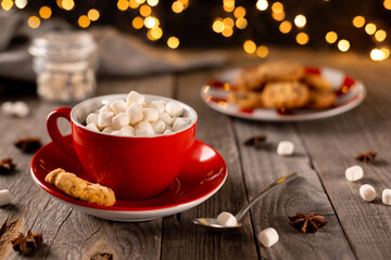 Hot chocolate with marshmallow in red cup on wooden table