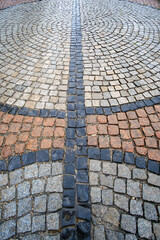 Traditional color stone pavement in perspective after the rain. Abstract background of old cobblestone pavement, soft focus