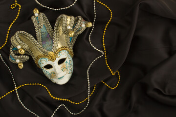 Top view of venetian carnival mask on the the black silk
