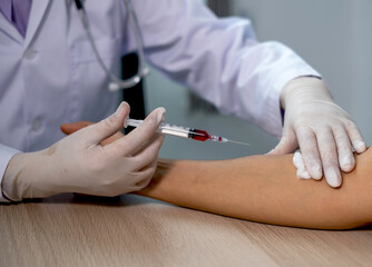 Doctors hands use syringe for collecting blood samples to analyze the cause of the illness