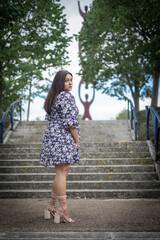 Mixed Race, Plus Sized Model Standing On Steps In Park