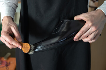 workshop for the care of shoes and other leather goods, a master brushes shoes