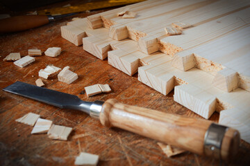 Dovetail joint on working table. Chisel and wood chips. Detail of wood joinery in spruce wood. Picture taken in woodworking workshop. 