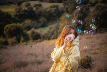 Making soap bubbles with a mask as an outdoor activity during autumn season. New reality adaptation...