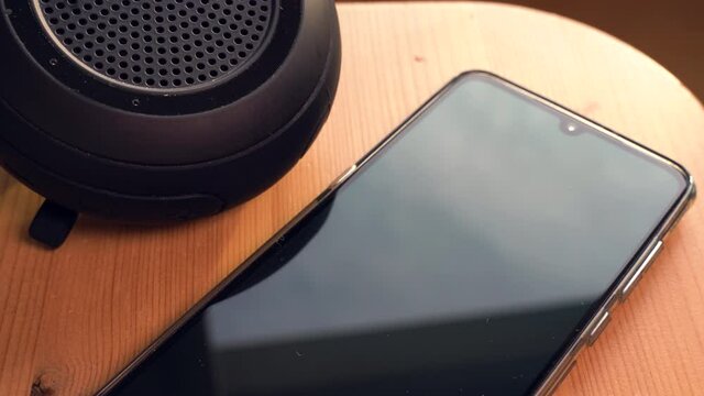 Wireless speaker connecting to a smartphone. Panning down to up