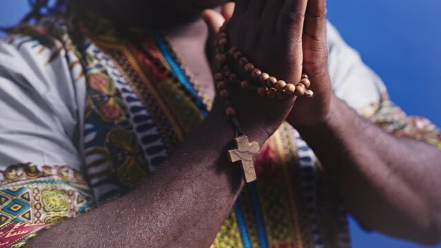 Folded Hands of Religious Black African Male With Rosary and Cross During Prayer Close Up