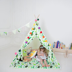 a little girl reads a book in a teepee © Alexander