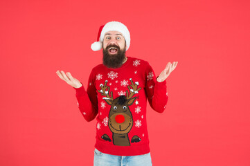 Fototapeta na wymiar happy bearded man in warm knitted sweater and santa claus hat celebrate winter holiday of chistmas and feel merry about xmas gifts, surprise