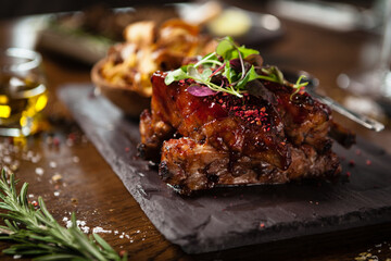 Pork ribs cooked at low temperature. Blackcurrant sauce, parsnip chips with Parmesan cheese. Delicious healthy meat food closeup served on a table for lunch in modern cuisine gourmet restaurant