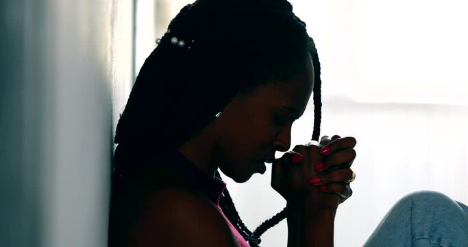 Hopeful woman praying that life will get better. Black African female prayer