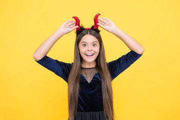 costume party fun. happy halloween. look at that. child in imp horns on yellow background. kid wear...