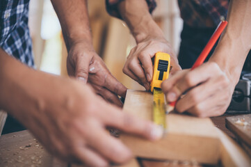 Craftsman carpenter team cooperating on building construction planning, working with wood