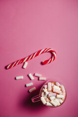 flat lay for Christmas or Valentine's Day theme. Cocoa with marshmallow and lollipop next to pink...