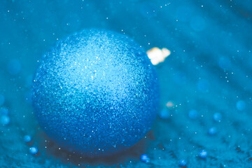 Fototapeta na wymiar Monochrome blue greeting card with a Christmas ball close.
