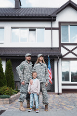 Family standing together and looking away near house