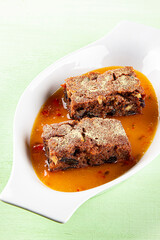 Russian cuisine. Lean dessert. Honey cake with sweet sauce in a white bowl. Restaurant menu. Background image, copy space