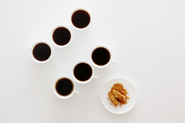 Sechs Kaffeetassen mit Keksen