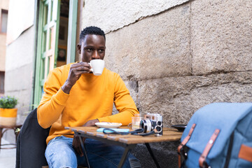 Black Man Drinking Coffee in a Cafe.