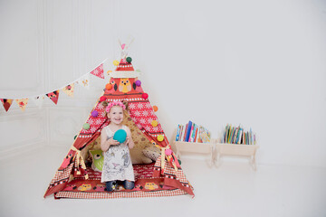 a little girl playing in a teepee © Alexander