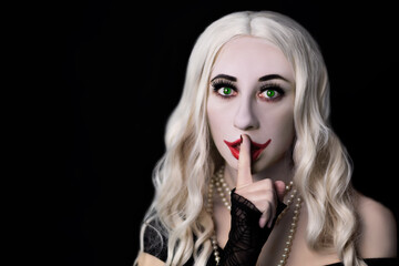 White haired woman vampire with green eyes on a black background for Halloween