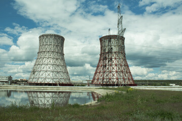 View of the power plant and cooling towers. The smoke goes out from a cooling tower of an operating...