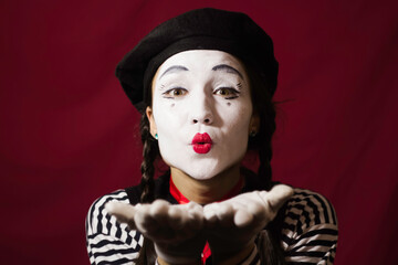 Beautiful girl mime sends air kiss .Beautiful mime girl smiling, looking at the camera.