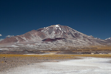 Volcanic landscape in the Andes mountain range. View of Volcano Incahuasi and natural salt flat in San Francisco pass, Catamarca, Argentina. 