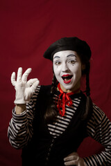Beautiful mime girl smiling, showing ok sign.