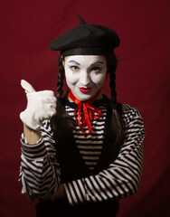 Beautiful girl mime smiles, shows thumb up.