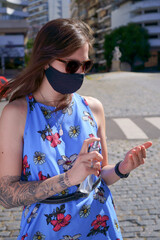 Woman outdoors during covid with mask and alcohol