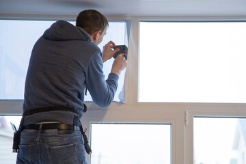 Fototapeta premium Installing window film in the office. Protection from ultraviolet radiation. Protective film.