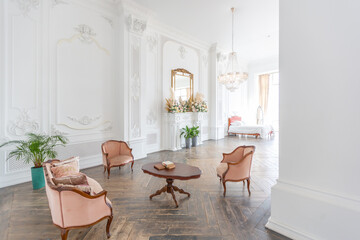 Fototapeta na wymiar royal baroque style luxury posh interior of large room. extra white, full of day light. high ceiling and walls decorated by stucco