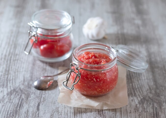 A spicy appetizer with garlic and horseradish in a transparent jar. Preparation for the winter. Cold prevention.
