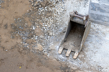 Digger claw of excavator, on gravel ground of construction building site, top down overhead view with copy space for text