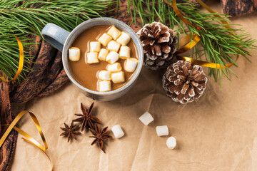 top view of Cup of coffee or cocoa with marshmallows with New year  tree or New year decor. Winter still life with a warm drink, scarf, anise stars and cones copy space